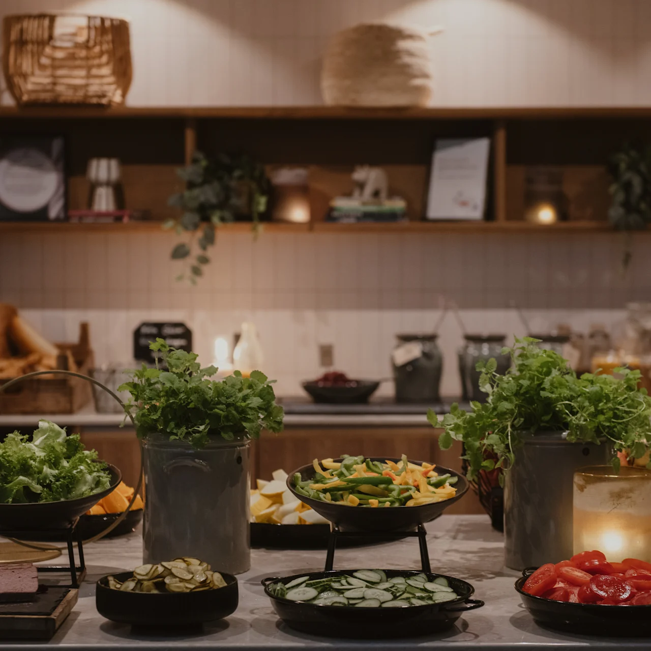 Ett buffébord visar olika grönsaker och örter i skålar, omgivna av ljus. Hyllor med växter och dekorationer skapar en mysig atmosfär. Sken text: "God appetitt. Vi ønsker deg en deilig 17. mai!"