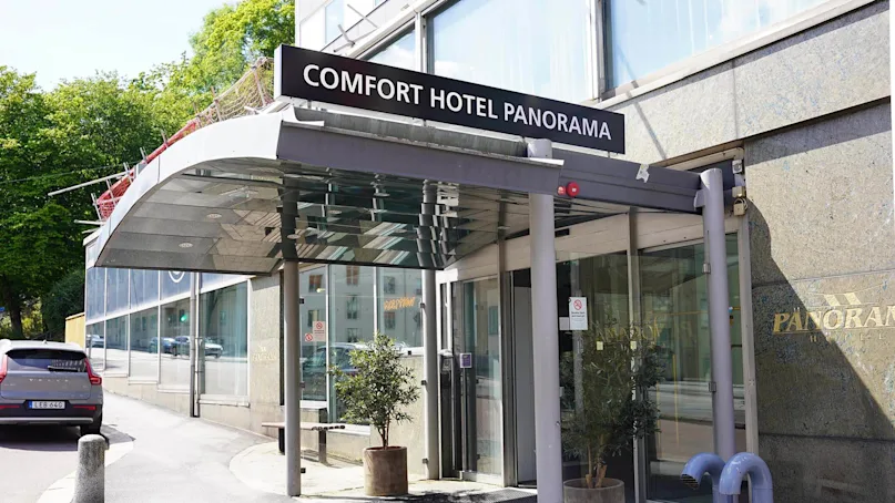The Comfort Hotel Panorama entrance with a sign, on a sunny day with a clear sky.