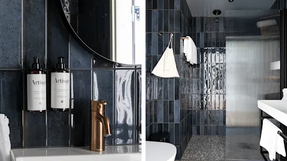 Moderne badeværelse på Hernö Gin Hotel. Mørke fliser, bronzearmatur, Body Lotion og Hand & Body Wash. Brusebad med tekstureret glas.