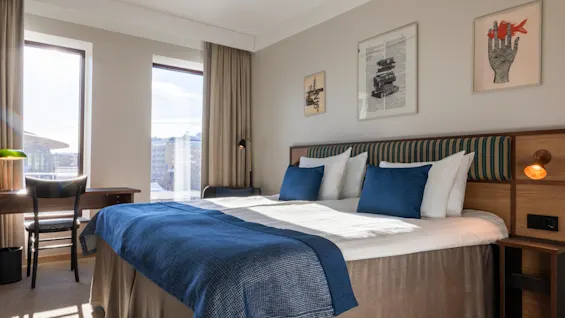 A bright and inviting hotel room at Quality Hotel The Book in Gothenburg, featuring a comfortable bed and a desk by the window.