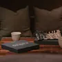 Viihtyisä näkymä shakkipelillä, kahdella keraamisella kupilla ja mustalla CHESS-laatikolla puupöydällä, valmiina peliin.