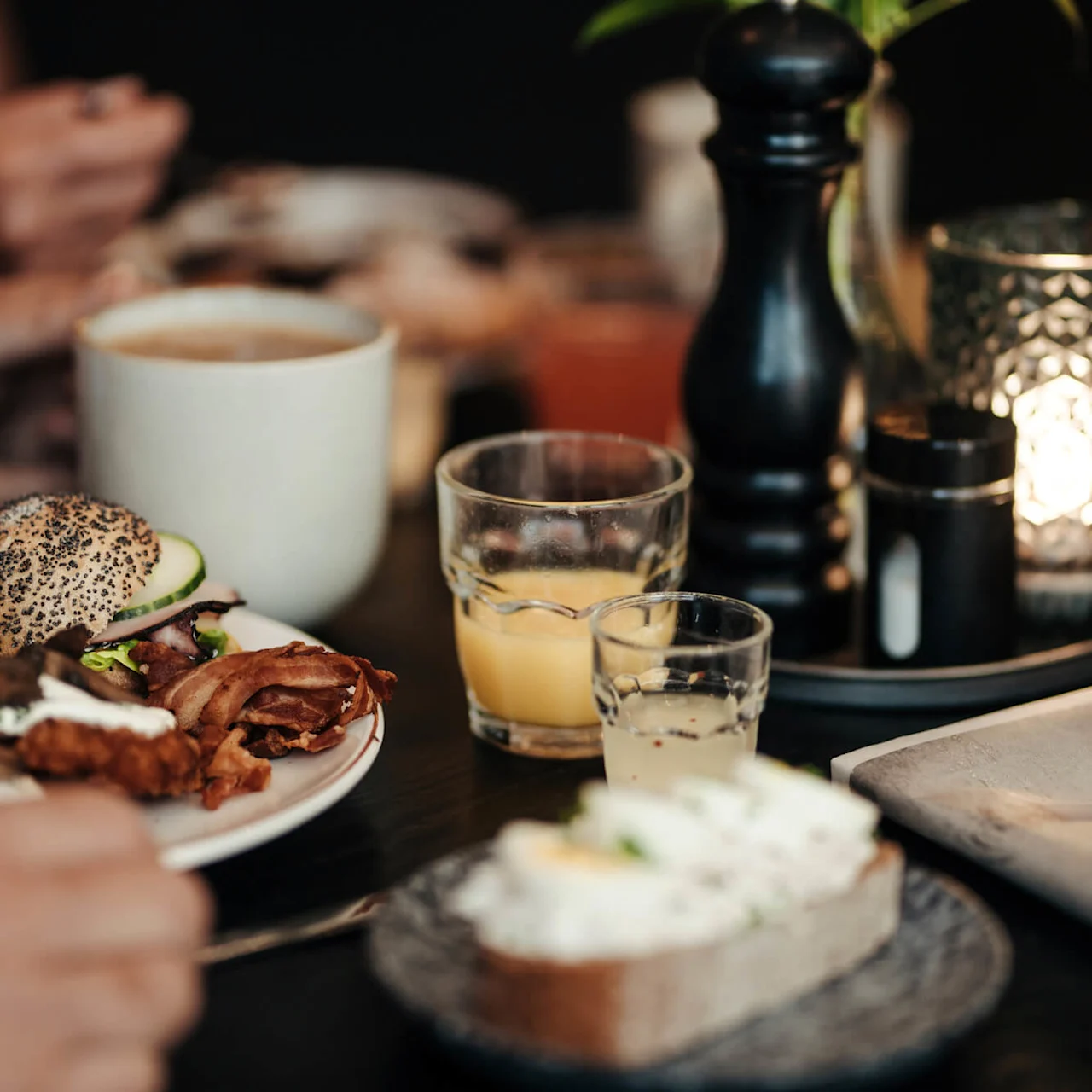 A table set with a variety of breakfast foods and beverages, in a cozy indoor setting.