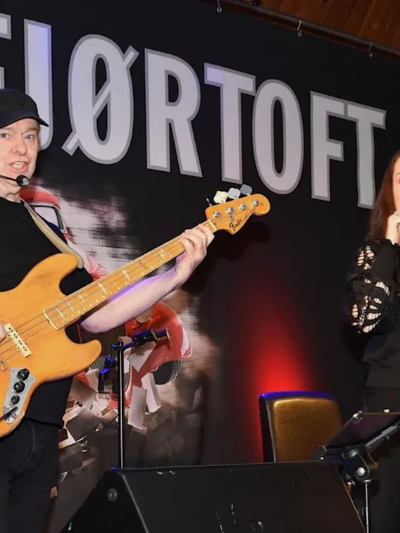 En livemusikk-duo som opptrer på scenen, bestående av en mann som spiller el-bass og en kvinne som synger.