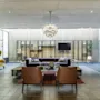Moderne og koselig hotellobby med stilfulle lenestoler, en mørk sofa og en iøynefallende taklampe.