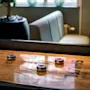 A wooden shuffleboard table with red and blue pucks, ready for a game. The words SHUFFLE and Play are visible on the table.