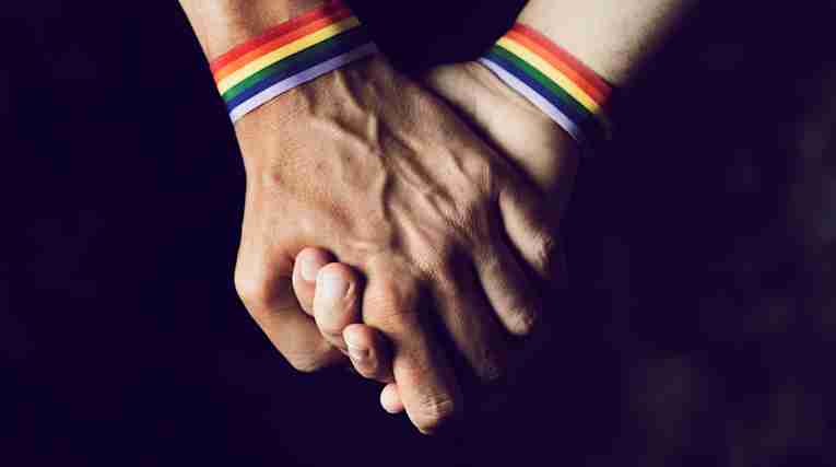 Närbild av gaypar som håller hand.