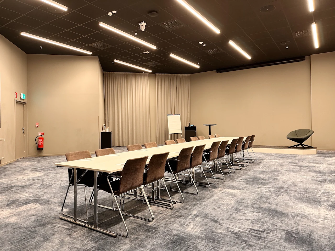 Moderne konferanserom på Quality Hotel Arlanda XPO med langt møtebord, stoler, whiteboard og presentasjonsområde.