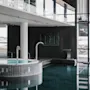 Indoor pool and hot tub at Farris Bad in Larvik, with large windows overlooking the sea and a modern, spacious design.