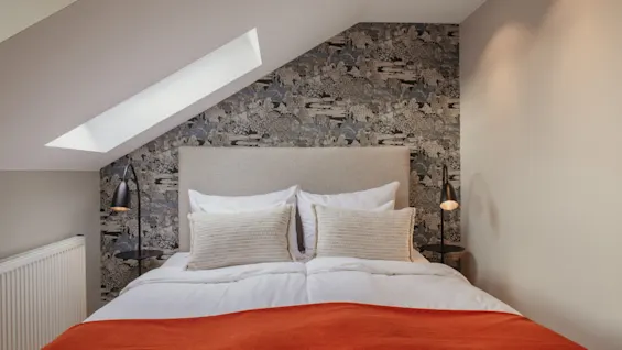 Slap af i dette indbydende soveværelse på Home Hotel Wellington, med en komfortabel seng, unikt tapet og et lyst ovenlysvindue.