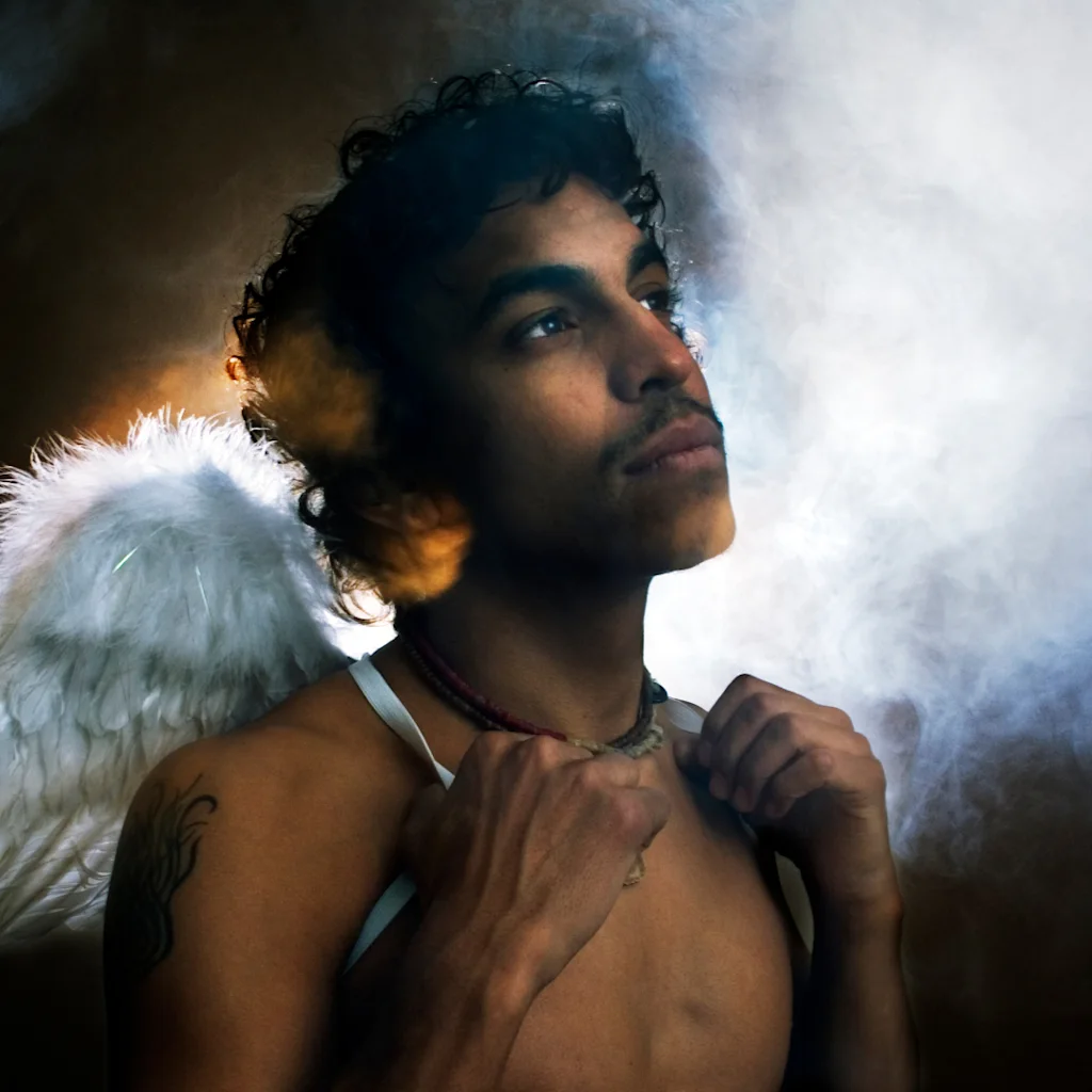 A person with an angel wing looks upward in mist. Event text: Fimbuktu 19 NOVEMBER OSLO SENTRUM SCENE 20 ARSJUBILEUM.