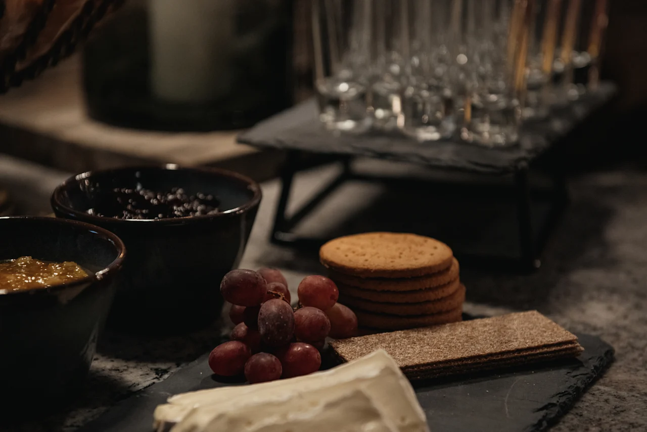 A delightful arrangement of cheese, grapes, and crackers, with bowls of spreads, ready to be enjoyed at Home Hotel Kung Oscar.