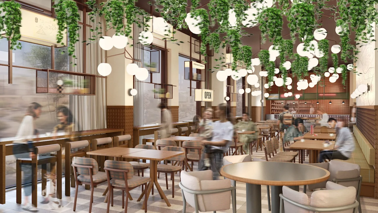 Restaurant interior features hanging green plants, round lamps suspended from the ceiling. Wooden tables are arranged with upholstered chairs. People are socializing. A sign reads "OPEN".