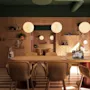 A modern meeting room with a large wooden table, stylish chairs, and warm round pendant lights.