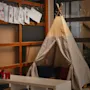 A children's play corner featuring a teepee tent, with drawings and mazes like LABYRINT and MILLA & RITA displayed.