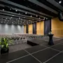 En modern hotellkonferenssal med rader av stolar vända mot en scen, redo för en presentation eller ett evenemang.