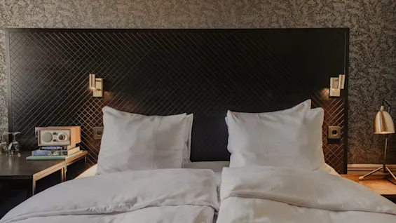 Ett inbjudande hotellrum på Home Hotel Grand, Helsingborg, med en mysig säng, sängbord och mjuk belysning för en avkopplande vistelse.