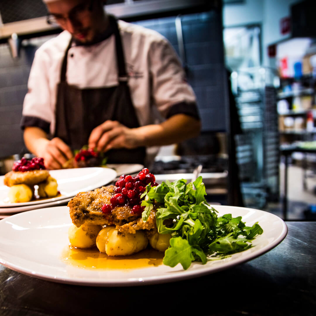 Varmlunch serveras på tallrikar med köket i bakgrunden på Meatings på Quality Hotel Carlia i Uddevalla, Sverige.