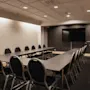 Ett modernt konferensrum på Home Hotel Grand, Helsingborg, med ett U-format bord, stolar och en stor skärm för presentationer.