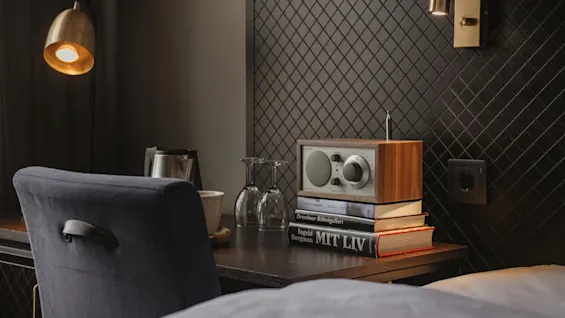 Hotellskrivbord med en radio på böcker: Dresdner Billedgalleri och Ingrid Bergman MIT LIV, med vinglas.