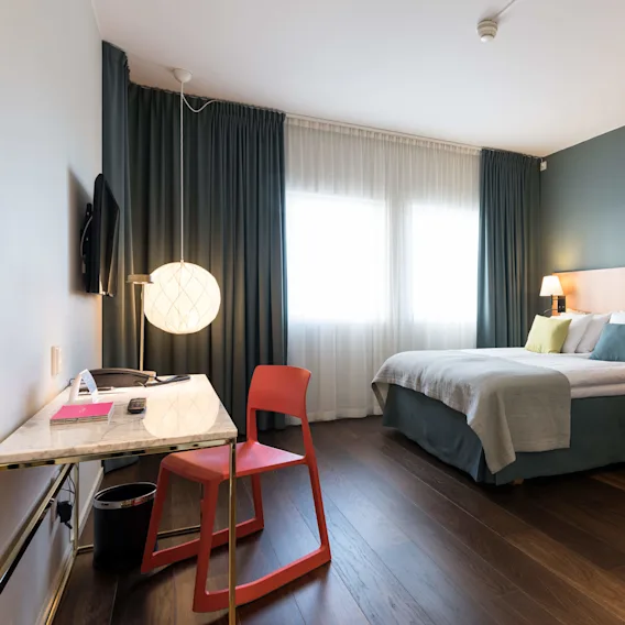 Standard dubbelrum med säng, skrivbord och stol på Quality Hotel Globe i Stockholm