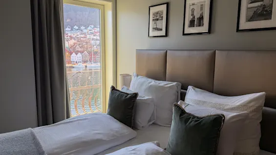 Et komfortabelt hotellrom med utsikt over en sjarmerende by ved vannet fra vinduet.