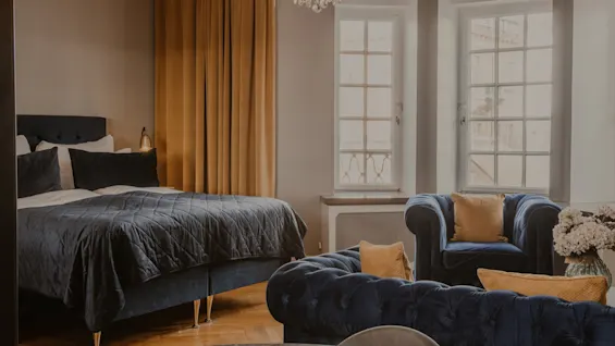 Ett lyxigt hotellrum på Home Hotel Grand, Helsingborg, med en bekväm säng och elegant sittgrupp.