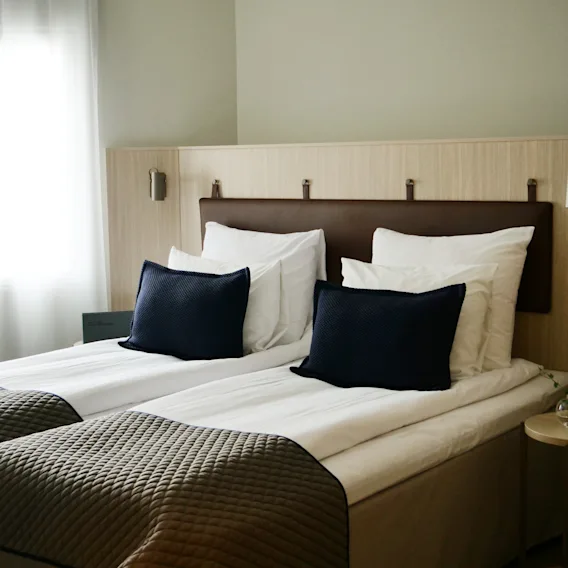 Ett bekvämt hotellrum på Quality Hotel Arlanda XPO med två prydligt bäddade sängar, redo för en avkopplande vistelse.