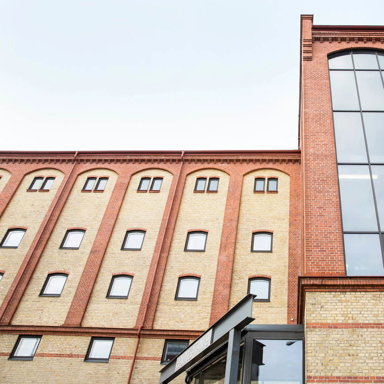 A renovated brick building with large windows under a clear sky.