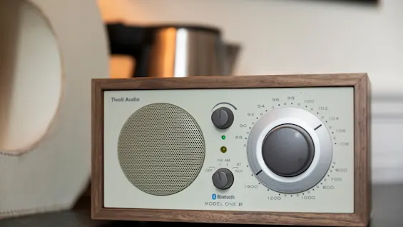 En klassisk radio med trækabinet og en stor indstillingsskive. Den viser FM AM, BT AUX, Bluetooth og MODEL ONE BT.