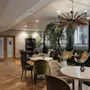 Home Hotel Uppsala: A cozy lounge area with various seating, a large plant, and doors labeled GYM and RELAX.