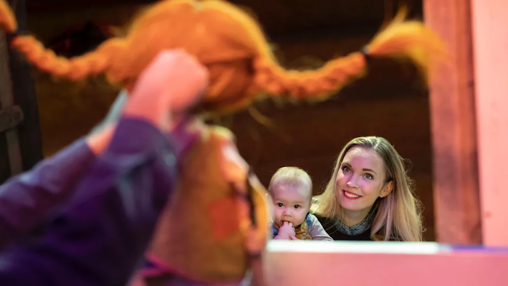 Family looking at one of the characters in Astrid Lindgren's books at children's museum Junibacken.