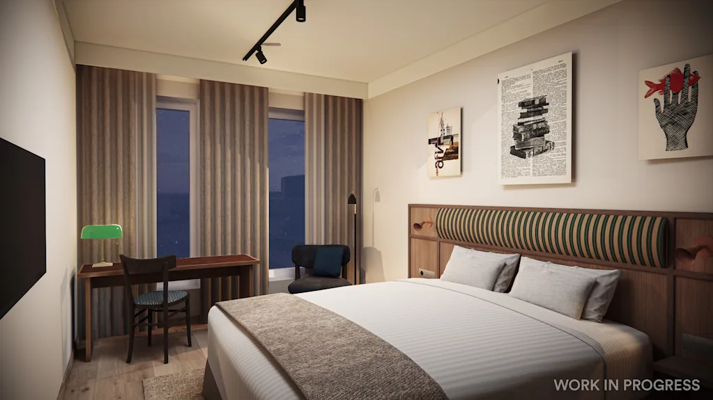 A modern hotel room at night with a bed, a desk, and artwork on the walls.