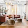 Moderne og koselig hotellobby med rosa sofaer, myke puffer og grønne planter under lunt lys.
