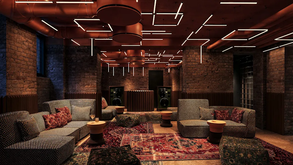 A cozy, modern lounge with brick walls, comfortable sofas, oriental rugs, and unique geometric ceiling lights.