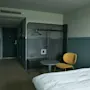 Ett välkomnande hotellrum på Stopover Hotel Falkenberg, designat för komfort med säng, sittplats och förvaringsutrymme.