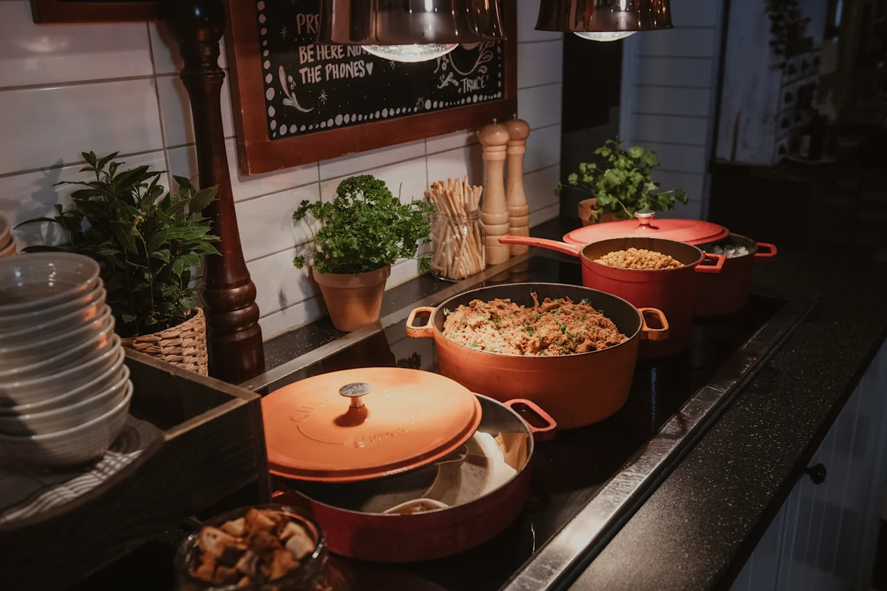 A buffet line with hot food in pots, fresh herbs, and a sign encouraging guests to "BE HERE NOT ON THE PHONES".