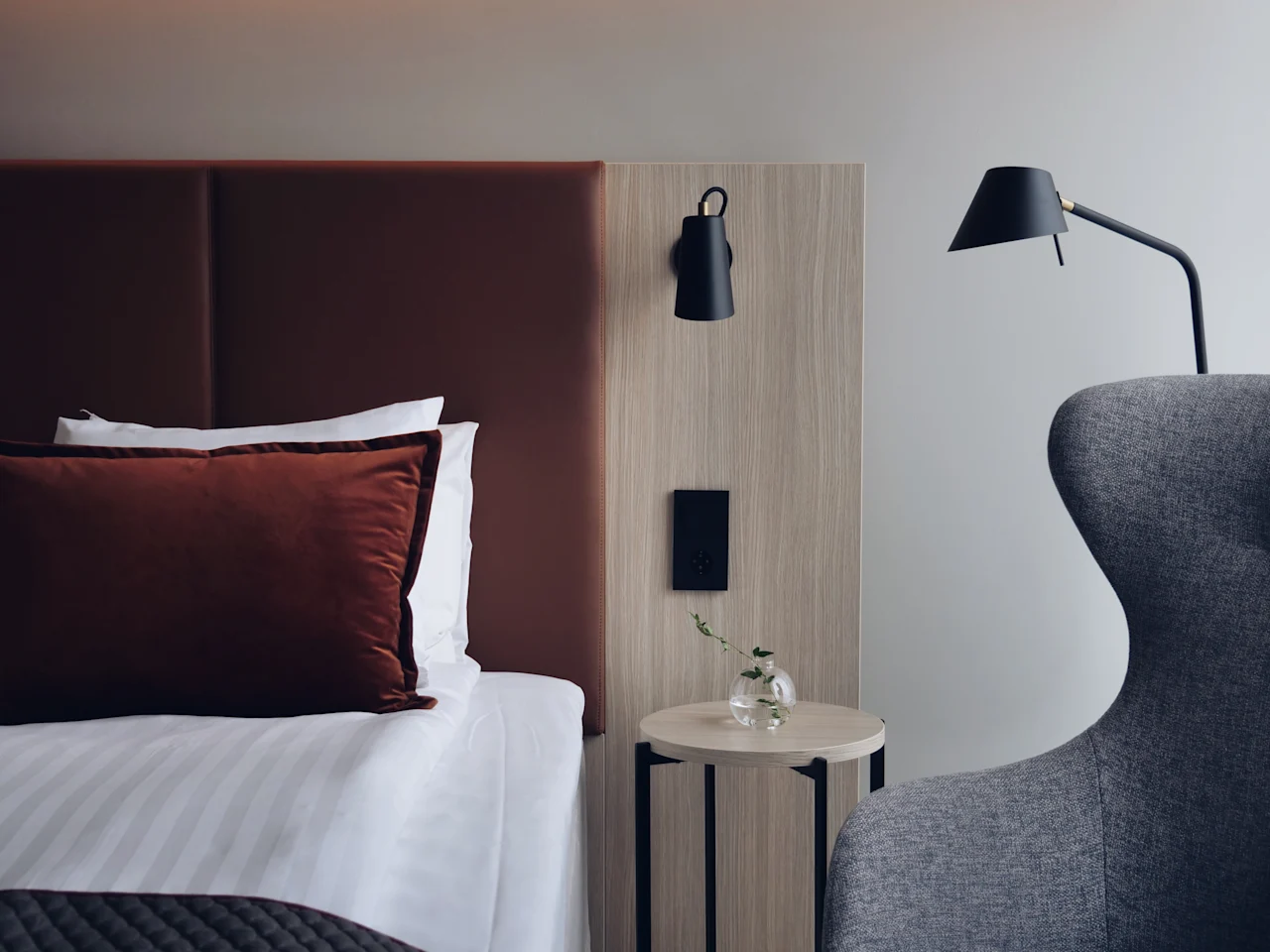 Et koselig og moderne hotellrom på Quality Hotel Arlanda XPO, med en komfortabel seng, nattbord og lesestol.