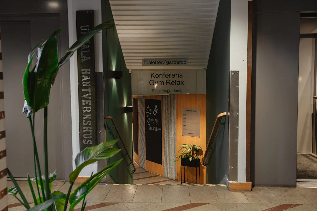 A welcoming entrance at Home Hotel Uppsala, guiding guests to Toaletter garderob, Konferens Gym Relax, and Uppsala Hantverkshus.