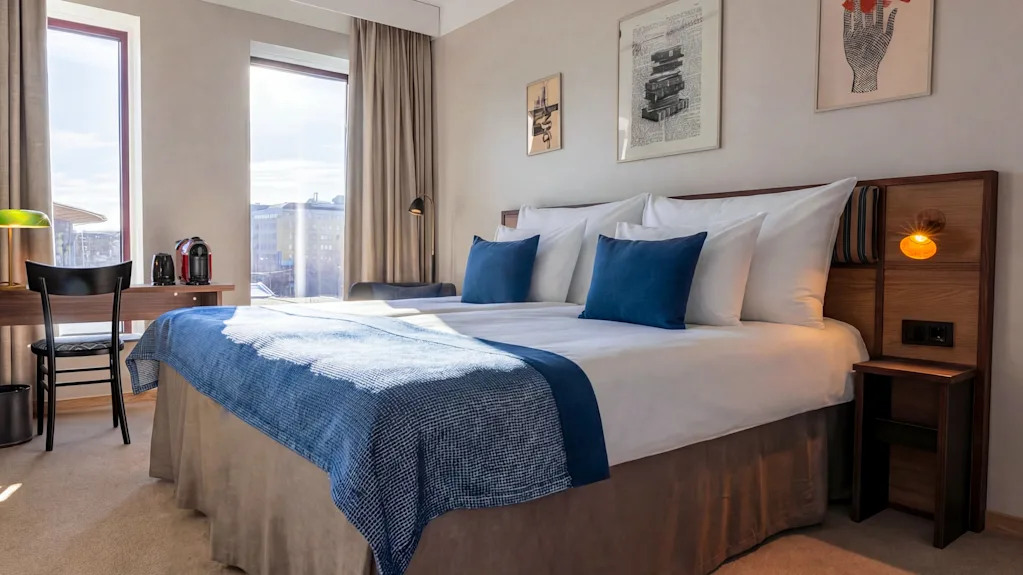 A bright and inviting hotel room at Quality Hotel The Book in Gothenburg, featuring a comfortable bed, desk, and city views.