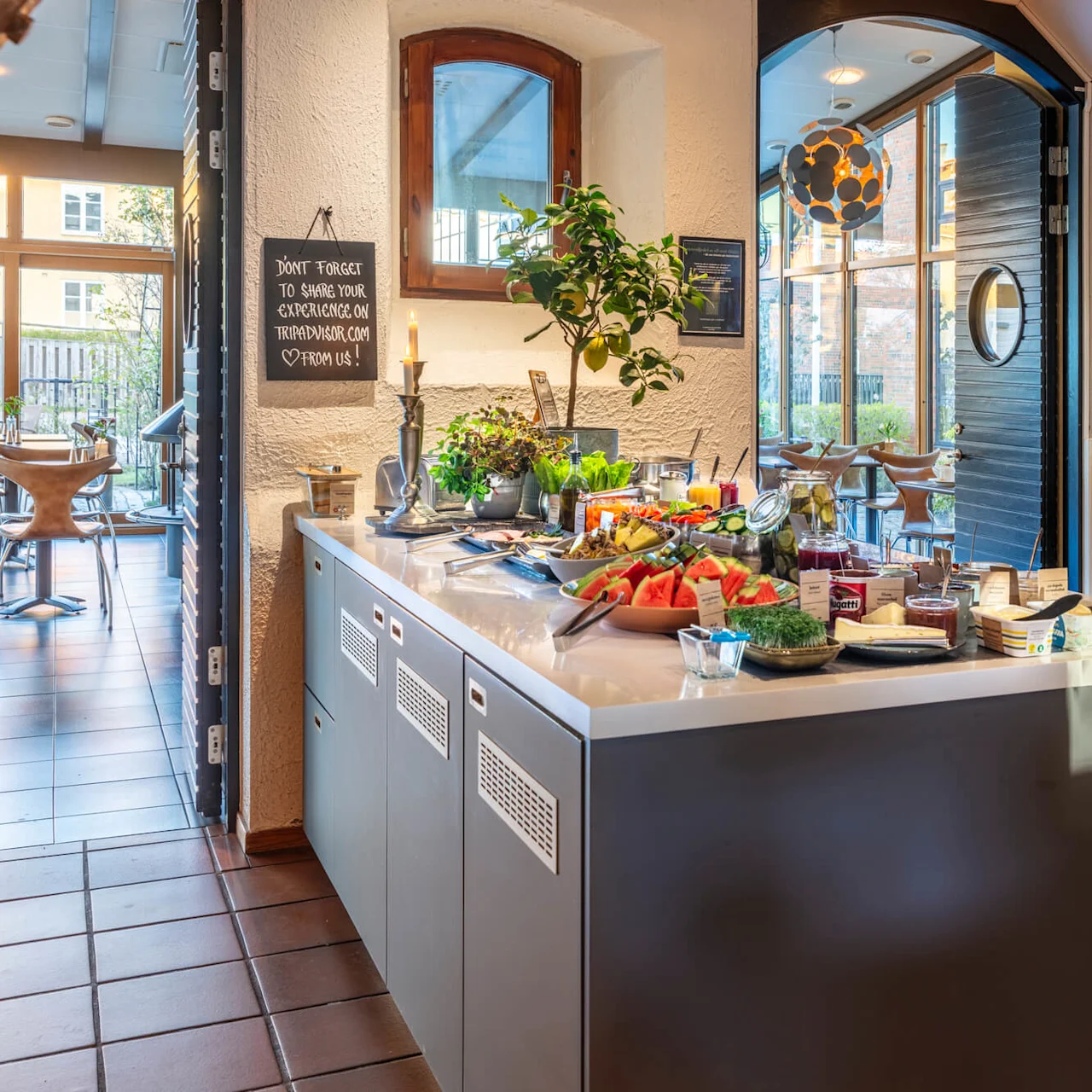 A breakfast buffet spread on counters against an interior setting with natural light, chairs in the background.