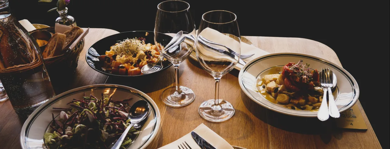 Food and wine on wooden table in a restaurant.