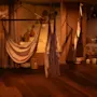 Rauhallinen, hämärästi valaistu huone, jossa on riippumattoja, hehkuvia kynttilöitä ja koristeellisia maljakoita, luoden rauhallisen ja rentouttavan tunnelman.