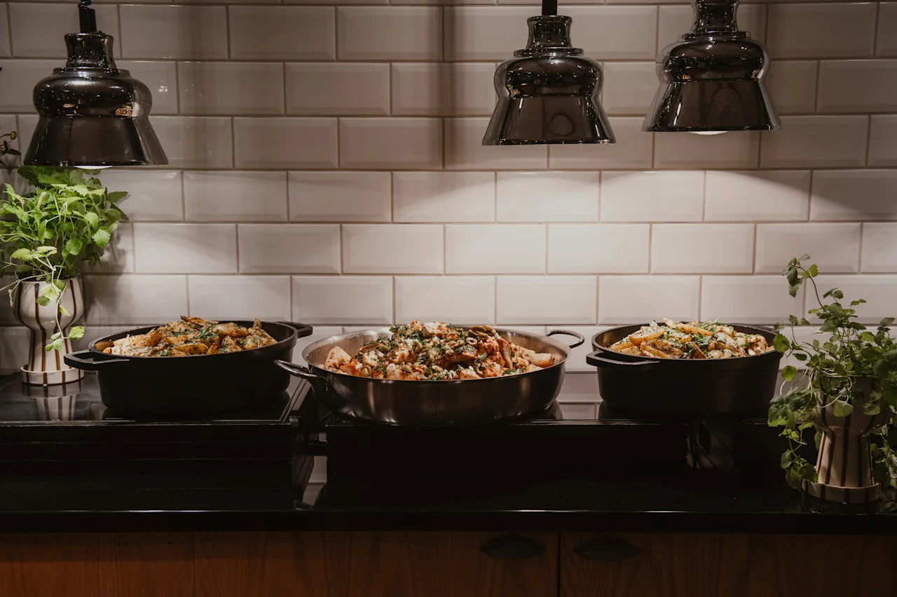 En buffé på Home Hotel Grand, Helsingborg, med tre stora grytor fyllda med läcker mat, garnerad med örter.