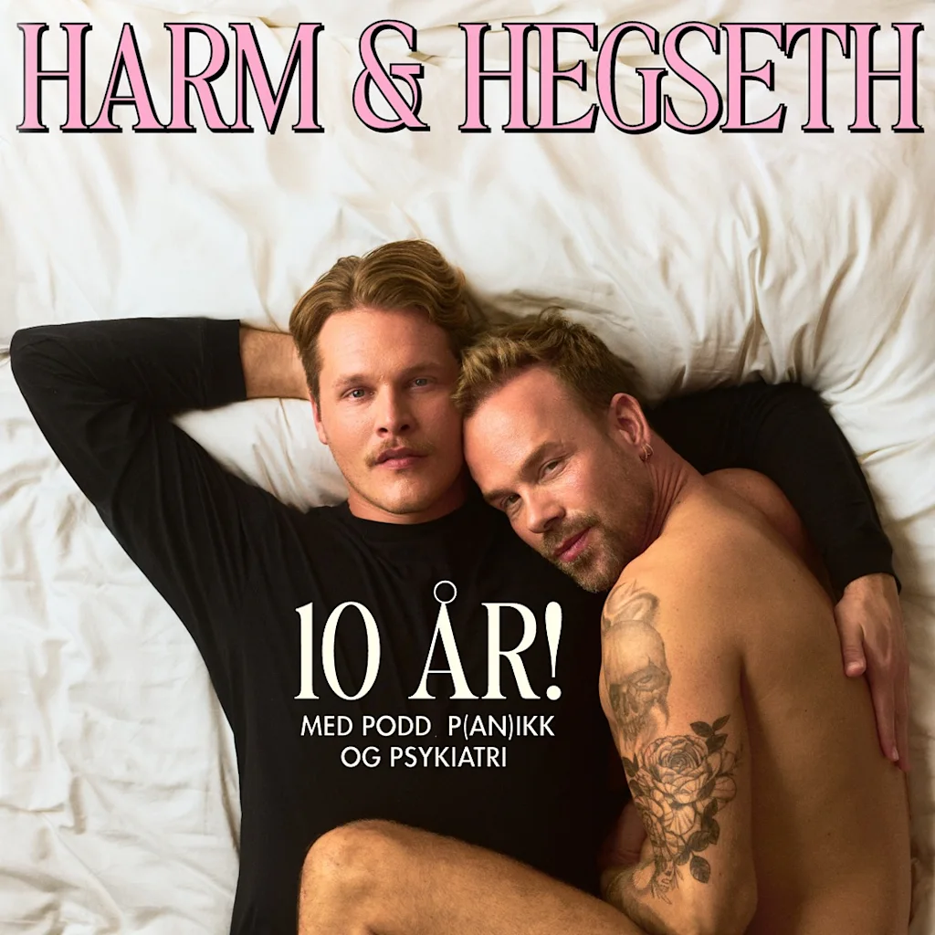 Two individuals lying closely on white sheets, one wearing a shirt with "10 ÅR! MED PODD, PJANIKK OG PSYKIATRI," under a title "HARM & HEGSETH." 