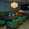 Et moderne møterom på Comfort Hotel City Göteborg med et ovalt bord, grønne stoler og en stor skjerm.