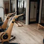A modern fitness room with stylish wooden exercise bikes and other workout equipment at Home Hotel Uppsala.