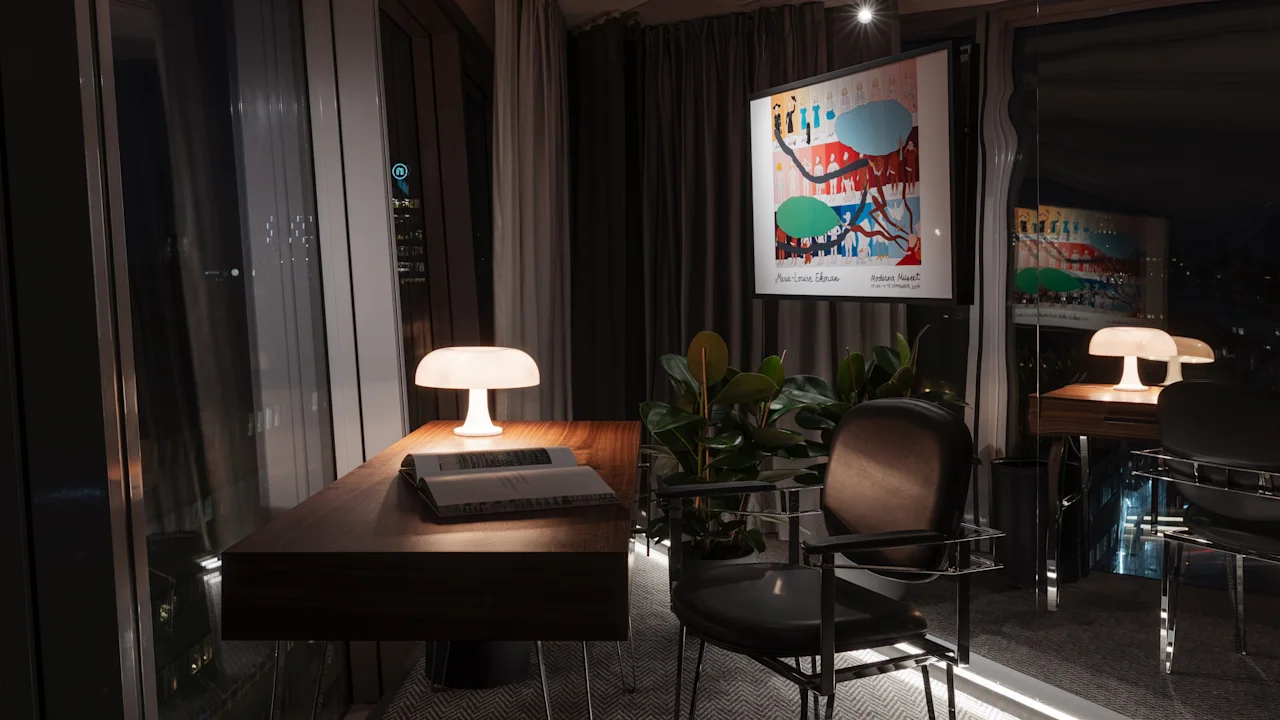 Clarion Hotel Sign, Stratum Suites. Sviitti, josta on näkymä Tukholmaan yöllä. Viihtyisä työpöytä lampun ja kirjan kera.