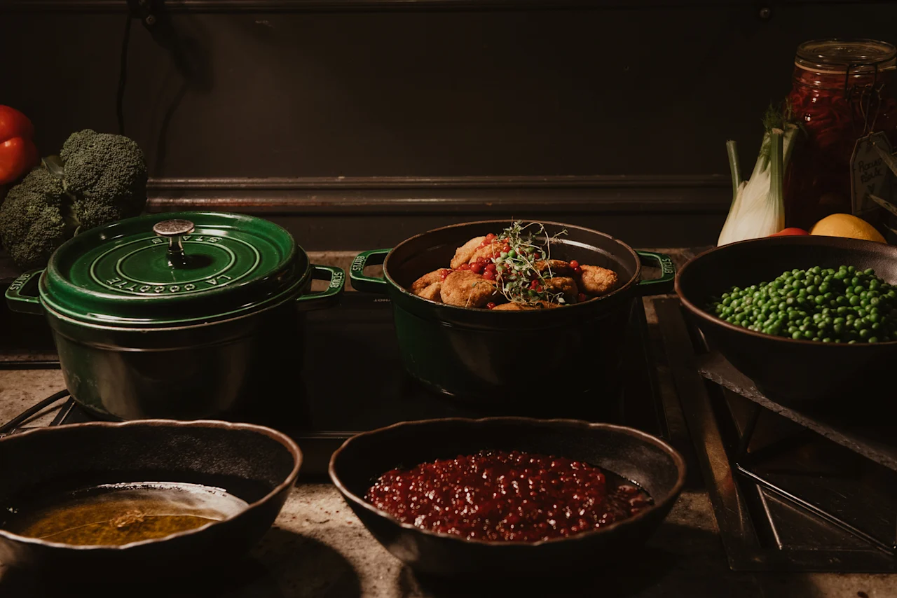 A warm buffet at Home Hotel Kung Oscar featuring hearty dishes like meatballs, peas, and berry sauce, ready to be served.