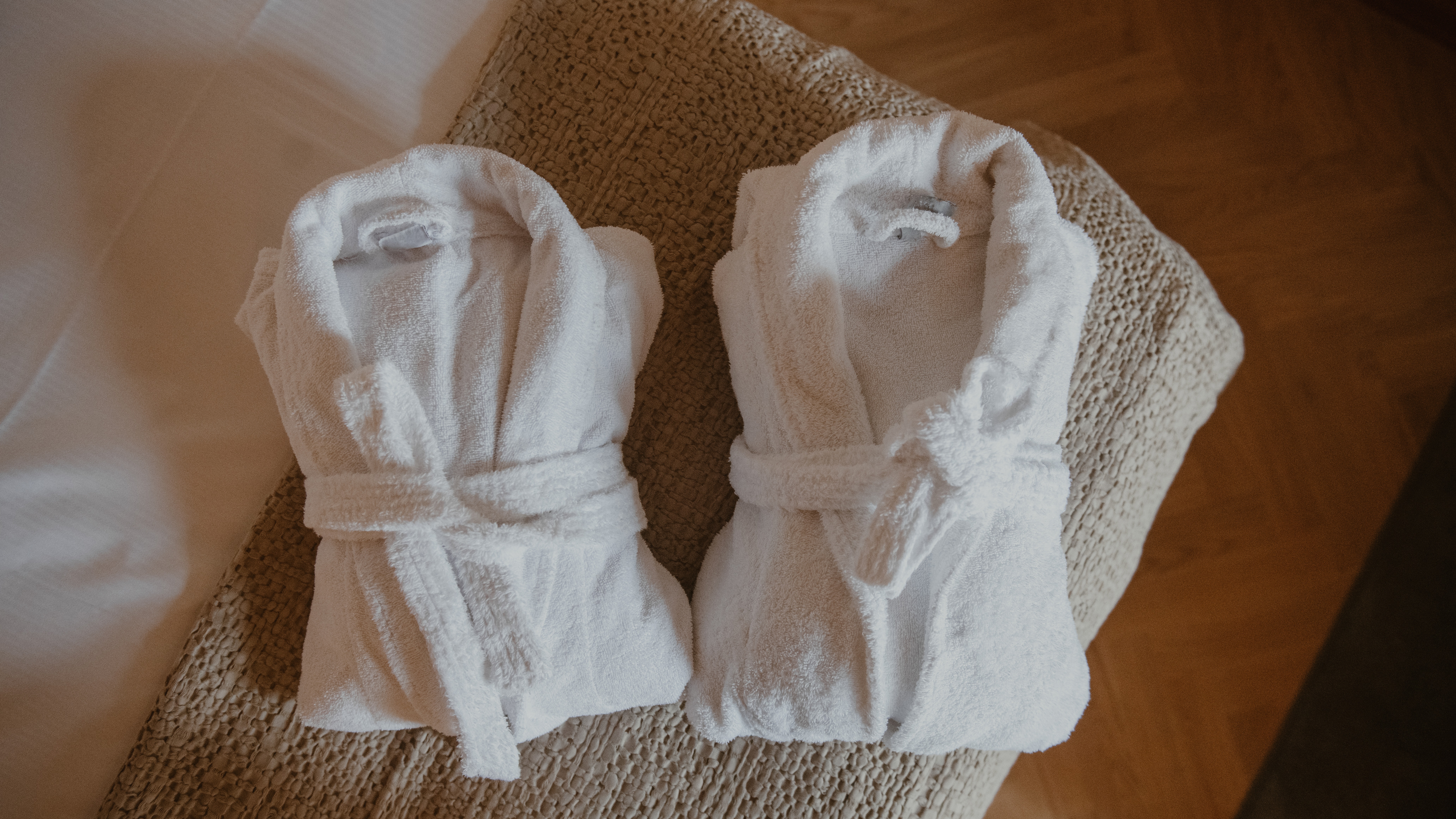 Two plush white bathrobes folded on a bed, inviting guests to relax and unwind.