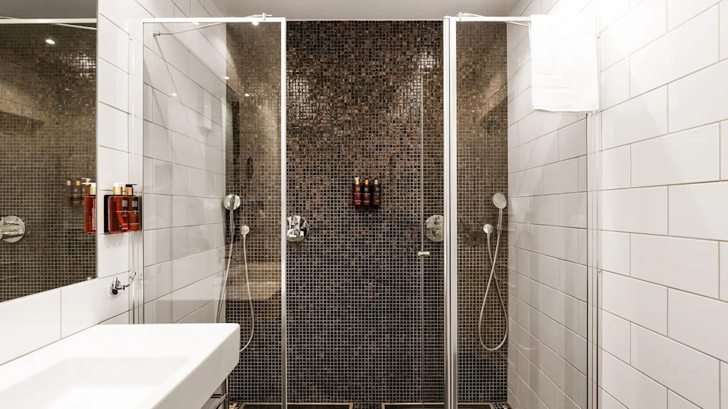 Moderne bad på Comfort Hotel Linköping City med romslig dusjområde, mosaikkfliser og elegant servant.